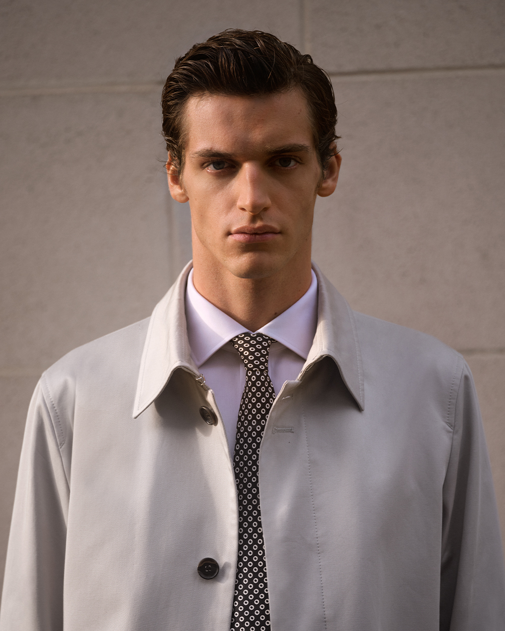 Man in grey coat and white shirt with tie